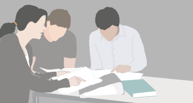 Drei Personen sitzen gemeinsam an einem Tisch und blättern in Lernmaterialien. Die vordere Person zeigt mit dem Finger auf einem Blatt, während die anderen sich über die Unterlagen beugen.