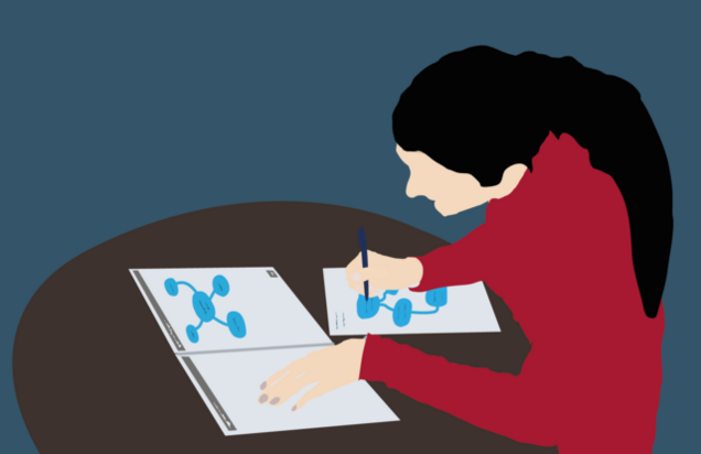 Eine Person mit dunklem Haar und rotem Oberteil sitzt an einem runden Tisch und schreibt auf einem der darauf liegenden Arbeitsblättern mit Mindmaps.