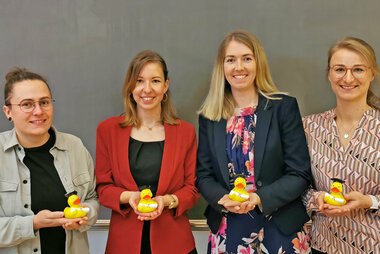 Die vier Absolventinnen halten als Geschenk eine Gummiente mit Doktorhut