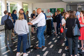 Kaffeepause im Foyer, Menschen an Stehtischen, die sich unterhalten